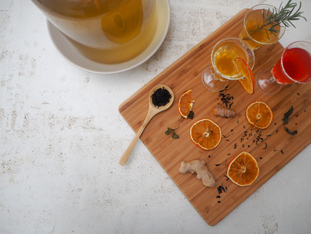 Glasses with a variety of homemade flavored kombucha tea and ingredients such as tea, ginger, citrus...