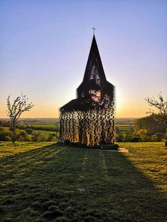 Steel see-through church in Borgloon (Hesbaye, Belgium), known as the art project Reading between the lines, during sunsetの写真素材