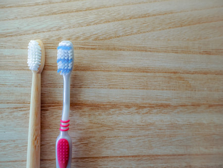 Plastic free lifestyle swap concept with plastic toothbrush and a bamboo toothbrush as sustainable...