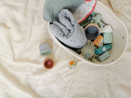 Gender neutral baby shower gift set for a newborn baby in soft colors. Bibs, building blocks, pacifier, chewing toy, etc. Gender neutral parenting concept.の写真素材