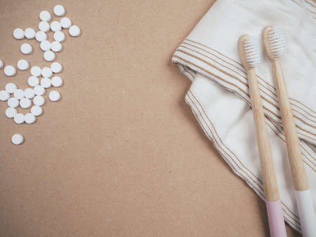 Bamboo toothbrush and dental tabs on a wooden background as a plastic free swap. Zero waste personal care products.の写真素材