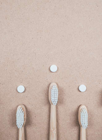 Bamboo toothbrush and dental tabs on a wooden background as a plastic free swap. Zero waste personal care products.の写真素材