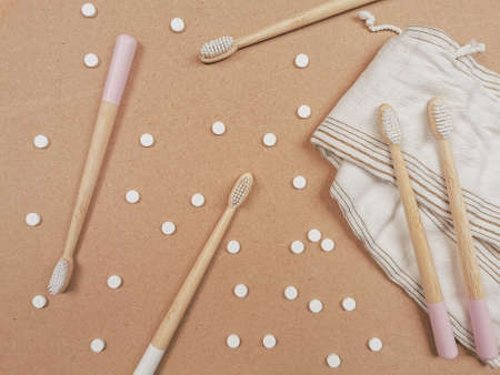 Bamboo toothbrush and dental tabs on a wooden background as a plastic free swap. Zero waste personal care products.の写真素材