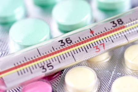 thermometer and pills as a backgroundの写真素材