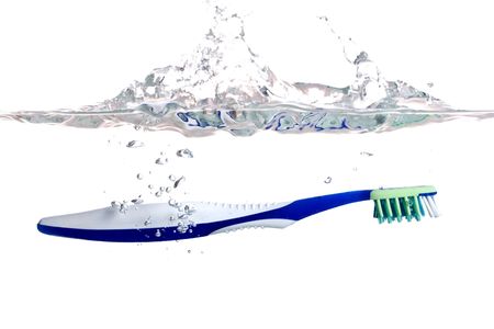 toothbrush falls into water on a white backgroundの写真素材