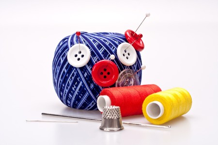 red and white pins in wool ball with buttons