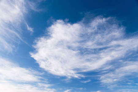 Deep blue sky and whispy cloudsの写真素材