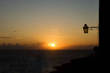 The setting sun with a lantern in the foregroundの写真素材