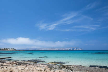 The beautiful turqouise and deep blue sea of the Comino Channel under a deep blue clear sky as seen from Armier Bay, Malta.の写真素材