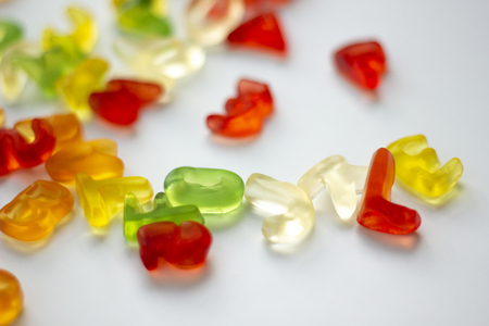 Shiny gummy alphabet letters on white backgroundの写真素材