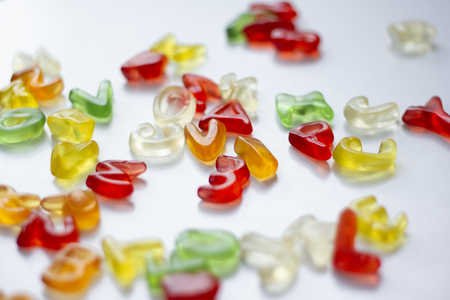 Shiny gummy alphabet letters on white backgroundの写真素材