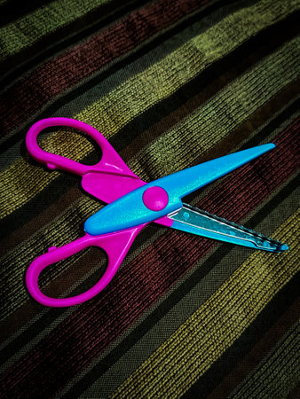 <p>Colorful scissors on a striped background. Shallow depth of field</p>の写真素材