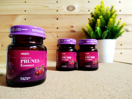 KUALA LUMPUR, MALAYSIA - OCTOBER 15, 2018 : Prunes essence in labelled bottles on wooden pallet.のeditorial素材