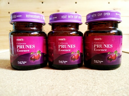 KUALA LUMPUR, MALAYSIA - OCTOBER 15, 2018 : Prunes essence in labelled bottles on wooden pallet.のeditorial素材