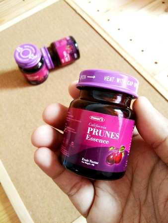 KUALA LUMPUR, MALAYSIA - OCTOBER 15, 2018 : Prunes essence in labelled bottles on wooden pallet.のeditorial素材