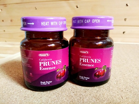 KUALA LUMPUR, MALAYSIA - OCTOBER 15, 2018 : Prunes essence in labelled bottles on wooden pallet.のeditorial素材