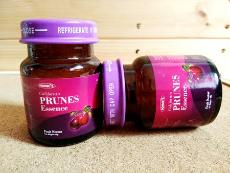 KUALA LUMPUR, MALAYSIA - OCTOBER 15, 2018 : Prunes essence in labelled bottles on wooden pallet.のeditorial素材