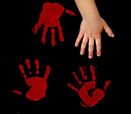 child's hand and red handprints on black background      の写真素材