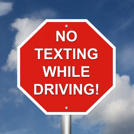 No Texting While Driving Sign mounted on a pole with sky background.の写真素材
