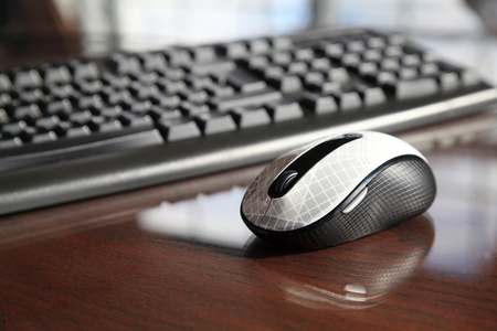 Keyboard and mouse on glass deskの写真素材