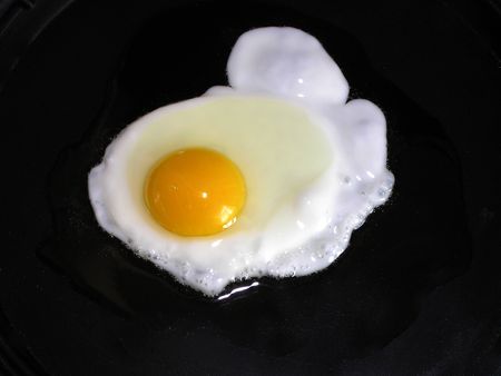 An egg is being cooked in a pan     の写真素材