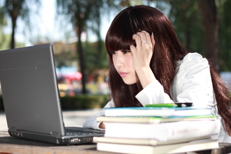 A smiling Asian student is studying の写真素材
