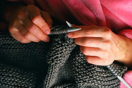 Young woman hands knitting a grey pulloverの写真素材