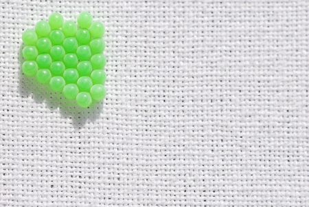 Macro view of aligned green eggs/ball on a white cotton linen.の写真素材