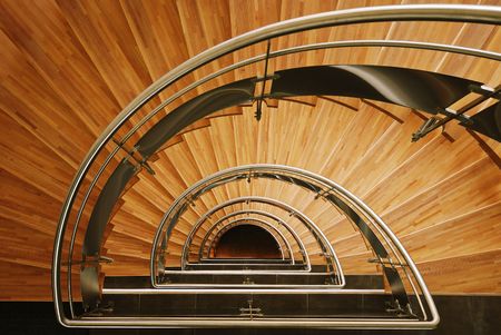 Down view of a semi elliptical interior wooden staircase
