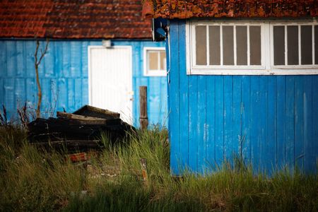 Blue shacks and a pile of wood near the ocean coast (Oleron / France) の写真素材