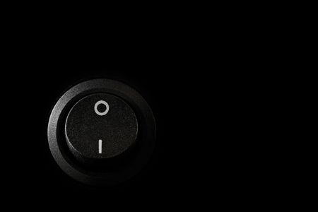 Black switch off button isolated on black backgroundの写真素材