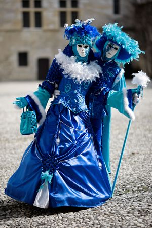 Couple with carnival costumes and masks in a castle court (Annecy/France)の写真素材