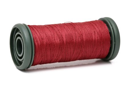 Red bobbin of thread isolated on a white backgroundの写真素材