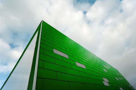 Modern architecture. Wide angle view of a green front under cloudy sky.の写真素材