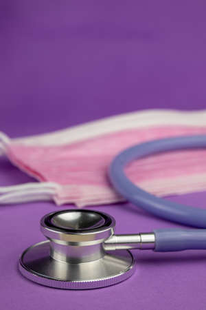 Stethosop on a purple background with pink medical maskの写真素材