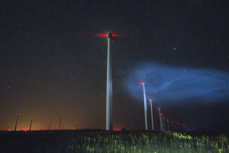 beautiful night photo of wind generators and stars with abstract lightingの写真素材