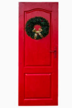Detail of a beautiful red door with Christmas decorations on a white backgroundの写真素材