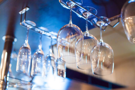 wineglasses hanging down on a barの写真素材
