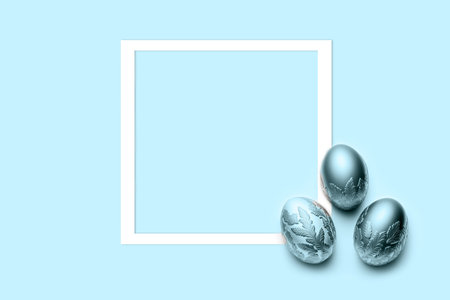 three blue eggs with frame on blue background. Flat lay, top view, copy space.の写真素材