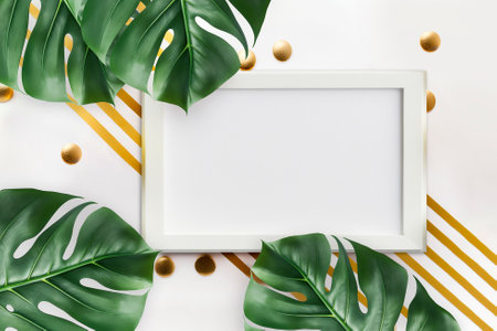 Empty photo frame mockup, tropical palm leaves Monstera on white background, flat lay, top viewの写真素材