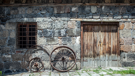 Metal wheel of an old car on a wall backgroundの写真素材