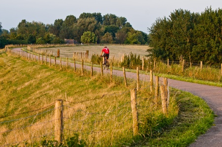 cyclist rides along a winding path in the early morningの写真素材