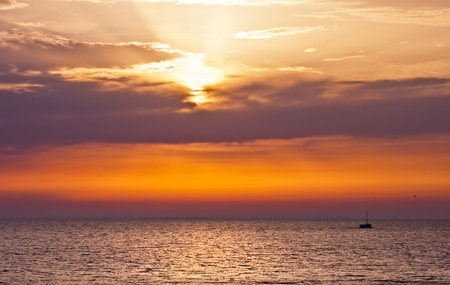 a lone boat in the sea at dawnの写真素材
