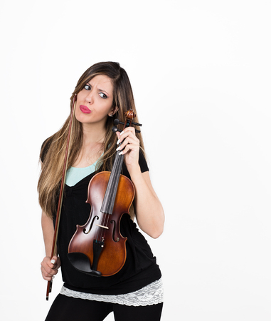 Beautiful puzzled student girl with her violinの写真素材