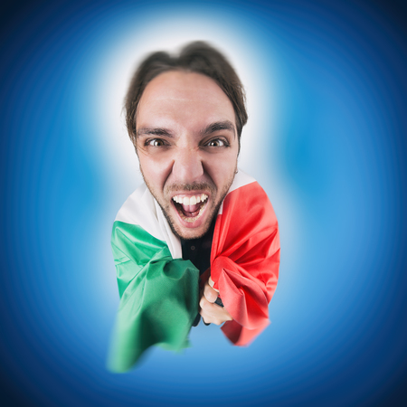 Italian soccer Fan holding the flag of Italy excited and happy for his teamの写真素材