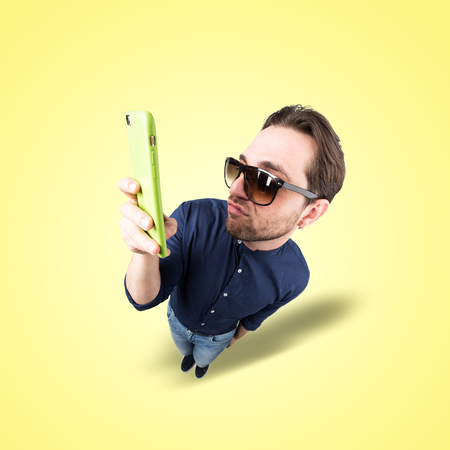 latin lover make a funny face, and take a self portrait with his smart phoneの写真素材