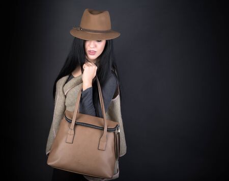 Fashion beautiful woman in country outfit, hat and bag on blackの写真素材