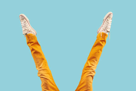 Cropped shot of white footwear, gumshoes on blue studio backgroundの写真素材