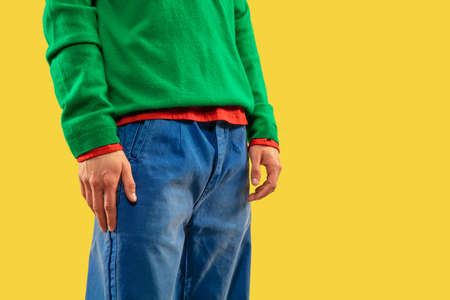 Cropped shot of young man in bright colored clothes on yellow background.の写真素材