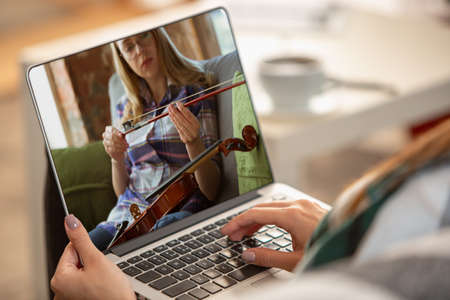 Close-up young woman learning play on musicial instruments online.の写真素材